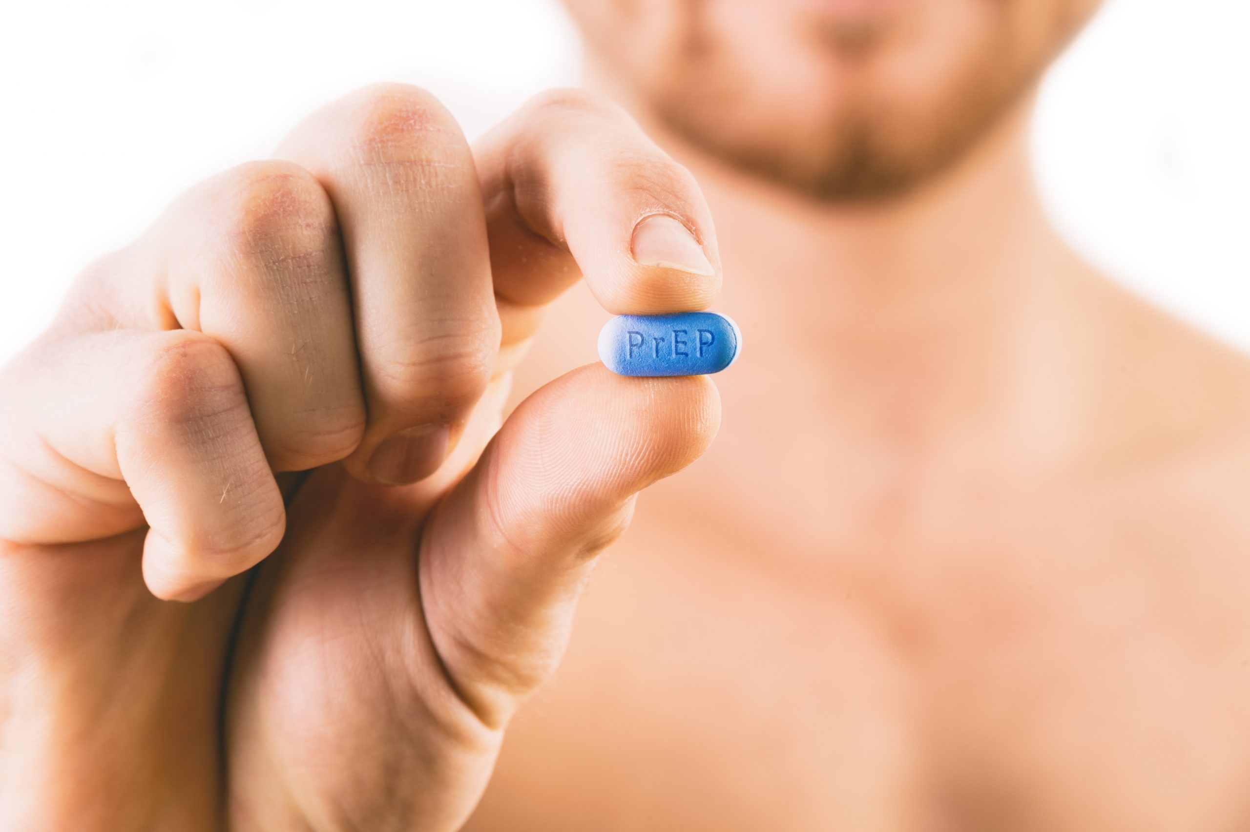Man holding a pill used for Pre-Exposure Prophylaxis (PrEP) to prevent HIV infection